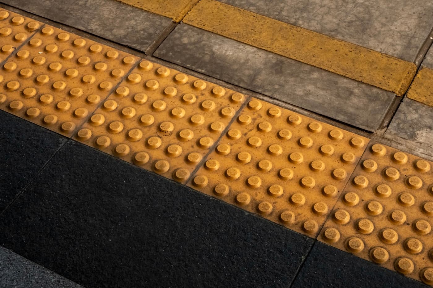 Tactile paving with raised dots on a pavement
