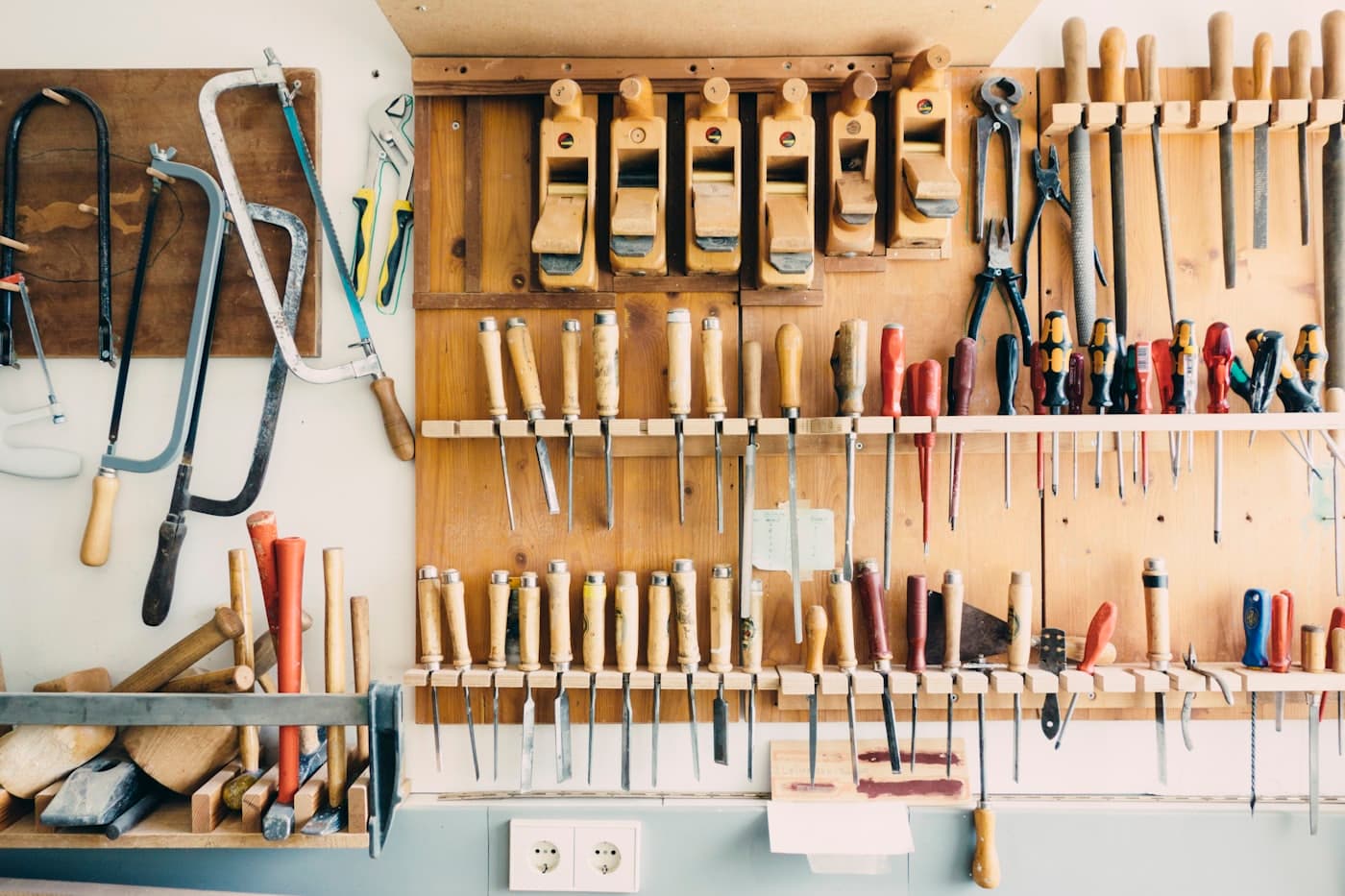 Hand tools arranged in a rack on a workshop wall